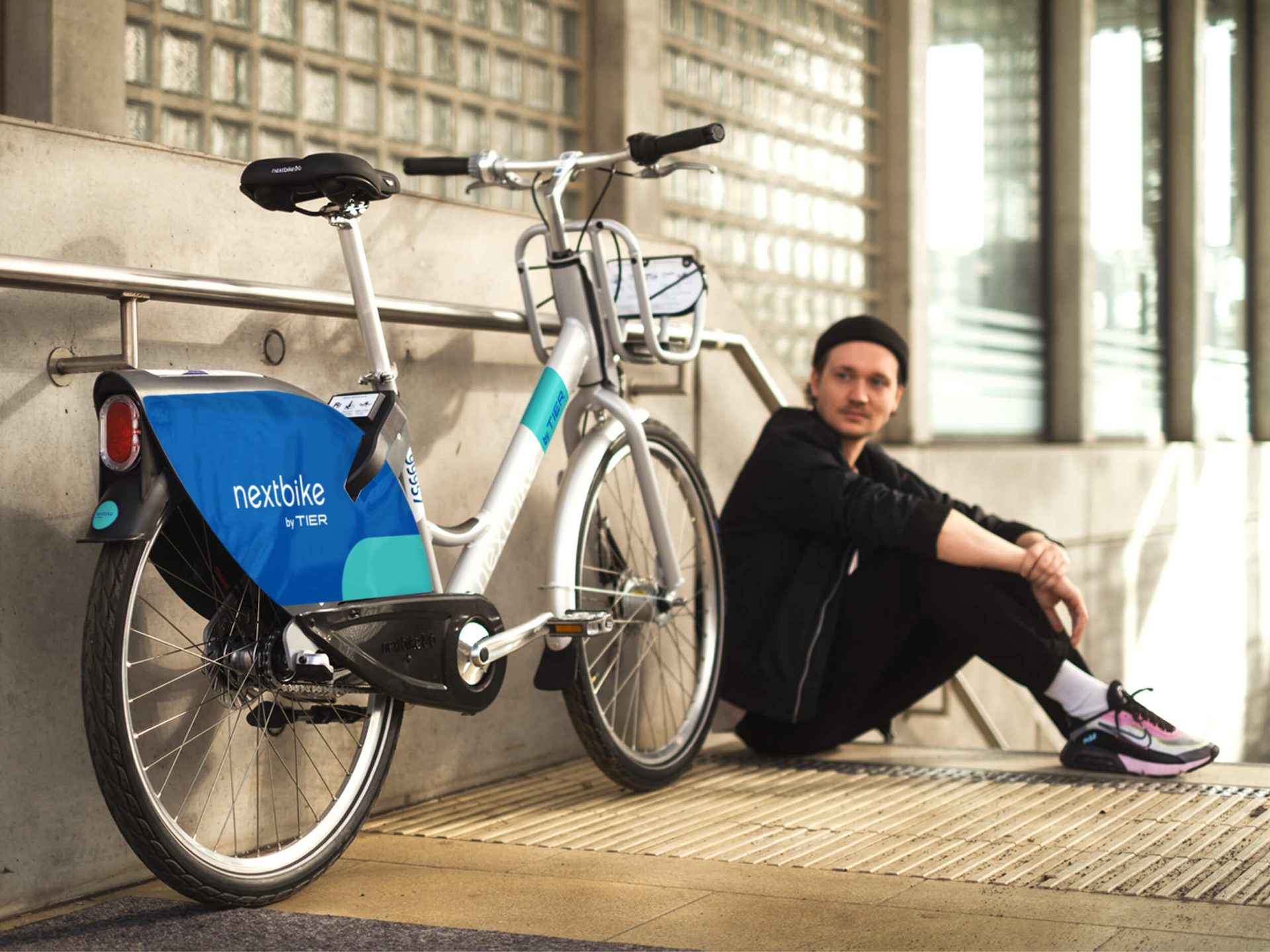 Ein Student sitzt neben Fahrrad von nextbike